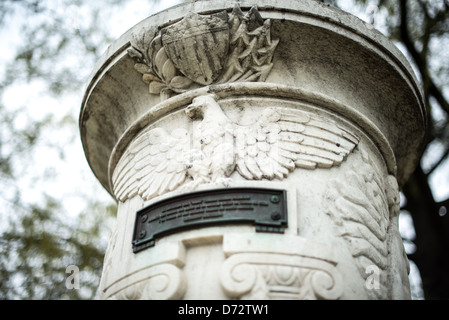 Cuban Friendship Urn Eagle and Shield Carving Washington DC / WASHINGTON DC — Ein geschnitzter Adler mit ausgestreckten Flügeln überragt einen stilisierten Schild auf der Cuban Friendship Urn im East Potomac Park. Dieses amerikanische patriotische Motiv ist in den weißen Marmor des Gedenkmals von 1928 gemeißelt, das nach dem Hurrikan vom 20. Oktober 1926 aus einer Säule des Havannas Maine Monument gemeißelt wurde. Die Nominierung des Nationalregisters stellt fest, dass der Adler – ein Grabsymbol seit römischer Zeit – die Vorderseite der Urne über der wichtigsten Bronzetafel krönt, die auf Spanisch geschrieben ist. Das Dekorationsprogramm AS Stockfoto