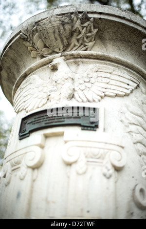 Cuban Friendship Urn Eagle and Shield Carving Washington DC / WASHINGTON DC — Ein geschnitzter Adler mit ausgestreckten Flügeln überragt einen stilisierten Schild auf der Cuban Friendship Urn im East Potomac Park. Dieses amerikanische patriotische Motiv ist in den weißen Marmor des Gedenkmals von 1928 gemeißelt, das nach dem Hurrikan vom 20. Oktober 1926 aus einer Säule des Havannas Maine Monument gemeißelt wurde. Die Nominierung des Nationalregisters stellt fest, dass der Adler – ein Grabsymbol seit römischer Zeit – die Vorderseite der Urne über der wichtigsten Bronzetafel krönt, die auf Spanisch geschrieben ist. Das Dekorationsprogramm AS Stockfoto