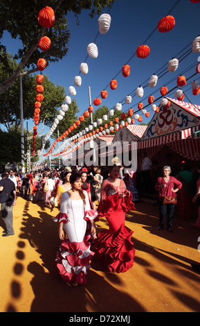 Mädchen tragen Flamenco-Kleider an die Feria de Abril in Sevilla, Spanien. Stockfoto