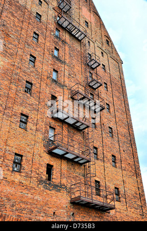 eine Feuerleiter an der Fassade von einem verlassenen Fabrikgebäude Stockfoto