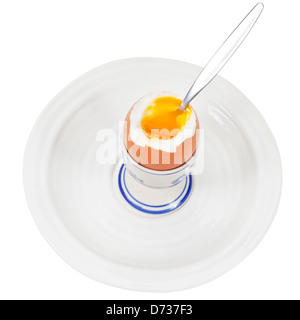 weich gekochtes Ei im Eierbecher mit Löffel auf weißen Teller isoliert auf weiss Stockfoto