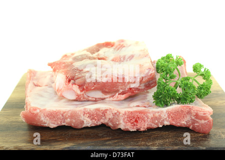 Rindfleisch spare Ribs mit Petersilie auf einem Holzbrett vor hellem Hintergrund Stockfoto