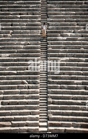 Ein Mann, Treppen im klassischen griechischen Theater im antiken Epidaurus, Argolis, Peloponnes, Griechenland. Stockfoto