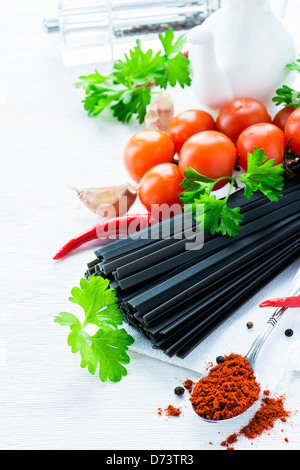 Schwarzen Teigwaren mit Tomaten, frische Kräuter, Gewürze und Öl Kanne, selektiven Fokus Stockfoto