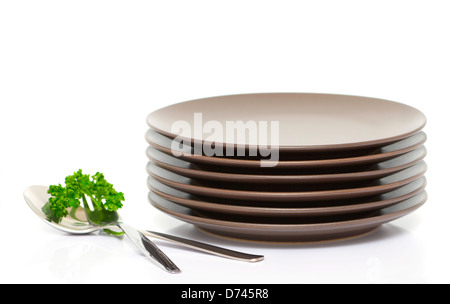 Stapel von braunen runden Teller mit Gabel, Löffel und Petersilie (mit Beispieltext) Stockfoto