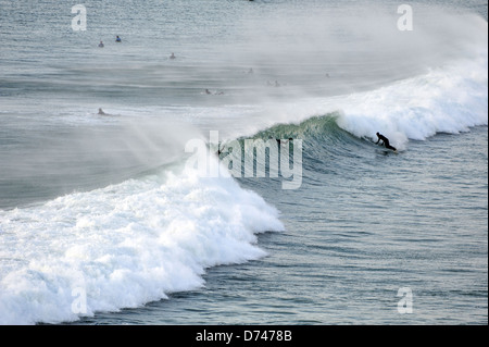 Surfer Reiten die Wellen an den Strand Fistral Cornwall Stockfoto