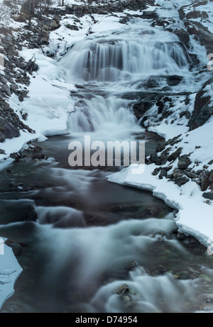 Wasserfall fließen in einen kleinen hinteren Fluss Stockfoto