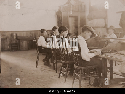 Dieses Bild vom Januar zeigt eine Gruppe von Jungen, die in einer Zigarrenfabrik in Tampa, Florida, arbeiten. Es beleuchtet die Arbeitsbedingungen und die Rolle von Kindern in der industriellen Arbeit des frühen 20. Jahrhunderts. Stockfoto