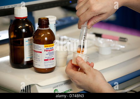 eine Krankenschwester, die Abgabe von Arzneimitteln auf einer Krankenstation. Stockfoto