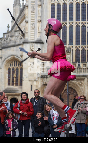 Street Performer jonglieren Messer während auf dem Monocycle außerhalb Bath Abbey, Bath, Somerset UK im April Stockfoto