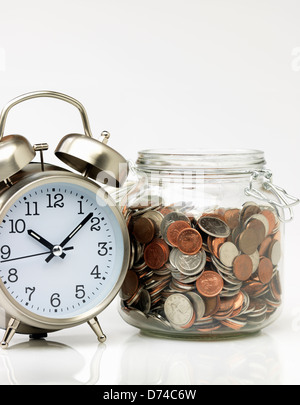 Zeit ist Geld, Uhr und Glas voller Geld Stockfoto