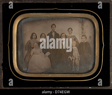 Ein ambrotypisches Foto aus dem Jahr 1864 mit einer Gruppe von acht Personen, darunter Kinder und Erwachsene. Das Bild bietet einen Einblick in die familiäre und soziale Dynamik der Mitte des 19. Jahrhunderts. Stockfoto