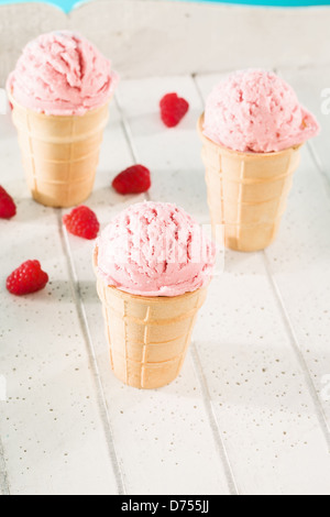 drei Himbeer Eis Zapfen auf weißem Holz Stockfoto