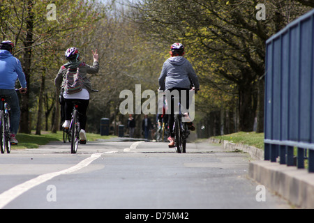 Gruppe junger Freunde auf ihren Fahrrädern auf einem breiten Radweg in Swansea am Meer entlang Stockfoto