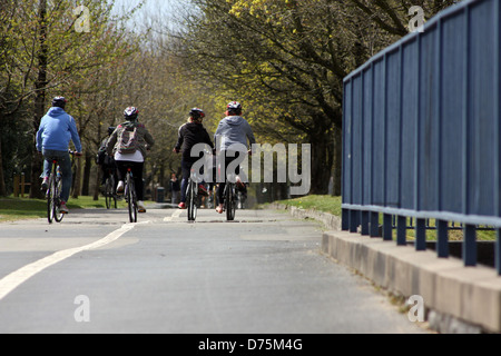 Gruppe junger Freunde auf ihren Fahrrädern auf einem breiten Radweg in Swansea am Meer entlang Stockfoto