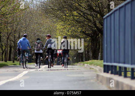 Gruppe junger Freunde auf ihren Fahrrädern auf einem breiten Radweg in Swansea am Meer entlang Stockfoto