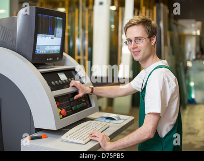 Arbeiter in der Glaserei Werkstatt Betrieb einer Schneidemaschine Stockfoto