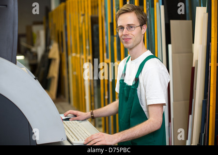 Arbeiter in der Glaserei Werkstatt Betrieb einer Schneidemaschine Stockfoto