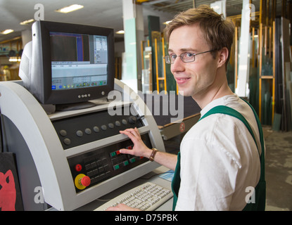 Arbeiter in der Glaserei Werkstatt Betrieb einer Schneidemaschine Stockfoto