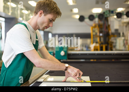 Arbeiter Schneiden von Glas in der Glaserei Werkstatt Stockfoto