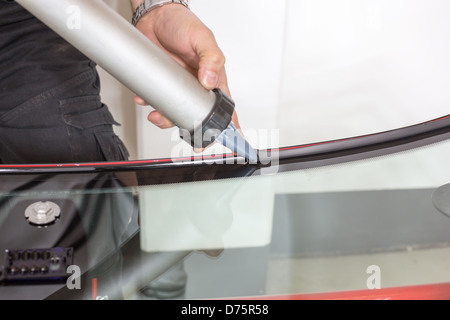 Glaserei Anwendung Gummidichtung Windschutzscheibe in garage Stockfoto