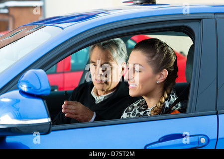 Fahrschule - junge Frau Steuern ein Auto, vielleicht hat sie eine Fahrprüfung vielleicht sie übt das Parken Stockfoto