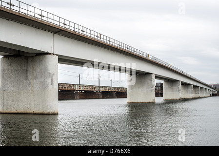 Long Bridge CSX Güterzug Potomac River Washington DC Frühling | WASHINGTON — Ein CSX-Güterzug, der gestapelte Intermodalcontainer transportiert, überquert die Long Bridge über den Potomac River, eingerahmt unter den Betonträgern des 14th-Street-Brückenkomplexes in Washington, D.C. Die Stahl-Schienenüberführung in ihrer heutigen Form stammt aus dem Jahr 1904 und bleibt die einzige Hauptbahnverbindung zwischen der Hauptstadt und Virginia, wobei rostige Metro-Gleise der Charles R. Fenwick Bridge daneben sichtbar sind. Stockfoto