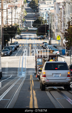 Eine Seilbahn und Auto Kopf eines berühmten steilen Straßen San Franciscos mit Tracks für die Seilbahn, eingebettet in die Straße hinunter. Stockfoto