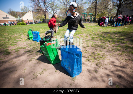 1. und 2. Klässler aus Nachbarschaft Schulen feiern Tag des Baumes beim recycling Relais spielen Stockfoto