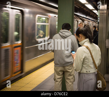 Reisende in der Times Square Station in der New Yorker u-Bahn-Linie auf Donnerstag, 25. April 2013 können jetzt ihre Mobiltelefone nutzen. Stockfoto