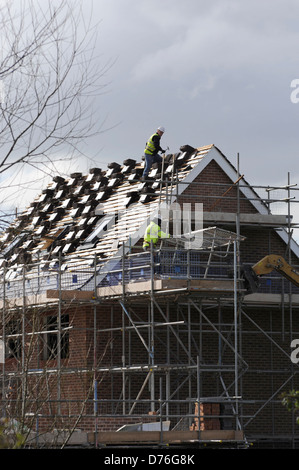 Dachziegel werden durch einen Dachdecker auf ein neues Build freistehendes Haus in Worcester fixiert. Stockfoto