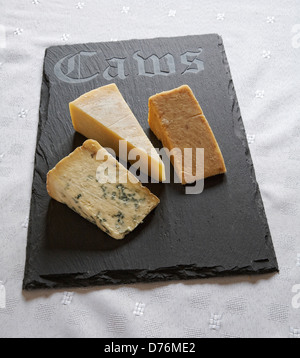 Walisischen Schiefer Käse vom Brett mit "Caws" (Walisisch für Käse) eingeschrieben auf sie mit einer Auswahl von Hartkäse. Stockfoto