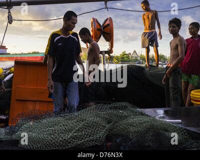 30. April 2013 - Mahachai, Samut Sakhon, Thailand - Burma Besatzungsmitglied auf einem thailändischen Fischtrawler kommen zurück in den Hafen in Mahachai. Die thailändischen Fischwirtschaft ist stark abhängig von Birma und kambodschanischen Migranten. Burmesische Migranten Mannschaft viele der Fischerboote, die Segel aus Samut Sakhon und Mitarbeiter vieler die Fisch verarbeitende Betriebe in Samut Sakhon etwa 45 Meilen südlich von Bangkok. Migranten zahlen so viel $700 (US) jeweils von der burmesischen Grenze nach Samut Sakhon für Jobs geschmuggelt werden, die weniger als $5,00 (U.S.) pro Tag zu zahlen. Auch gab es Berichte, dass einige birmanische Arbeiter missbraucht und in s statt Stockfoto