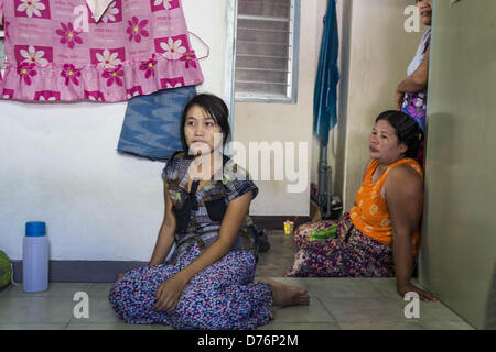 30. April 2013 - Mahachai, Samut Sakhon, Thailand - birmanischen Frauen Fernsehen in ihrer Wohnung in der thailändischen Fischerei Hafen Mahachai. Die thailändischen Fischwirtschaft ist stark abhängig von Birma und kambodschanischen Migranten. Burmesische Migranten Mannschaft viele der Fischerboote, die Segel aus Samut Sakhon und Mitarbeiter vieler die Fisch verarbeitende Betriebe in Samut Sakhon etwa 45 Meilen südlich von Bangkok. Migranten zahlen so viel $700 (US) jeweils von der burmesischen Grenze nach Samut Sakhon für Jobs geschmuggelt werden, die weniger als $5,00 (U.S.) pro Tag zu zahlen. Auch gab es Berichte, dass einige birmanische Arbeiter missbraucht werden eine Stockfoto