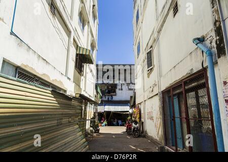 30. April 2013 - Mahachai, Samut Sakhon, Thailand - eine Gasse zwischen burmesischen Geschäfte und Wohnungen in der thailändischen Fischerei Hafen Mahachai. Die thailändischen Fischwirtschaft ist stark abhängig von Birma und kambodschanischen Migranten. Burmesische Migranten Mannschaft viele der Fischerboote, die Segel aus Samut Sakhon und Mitarbeiter vieler die Fisch verarbeitende Betriebe in Samut Sakhon etwa 45 Meilen südlich von Bangkok. Migranten zahlen so viel $700 (US) jeweils von der burmesischen Grenze nach Samut Sakhon für Jobs geschmuggelt werden, die weniger als $5,00 (U.S.) pro Tag zu zahlen. Es gab auch Berichte, dass einige birmanische Arbeiter missbraucht werden und er Stockfoto