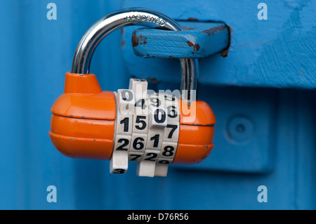 Orange-Kombination Vorhängeschloss auf blaue Tür Stockfoto