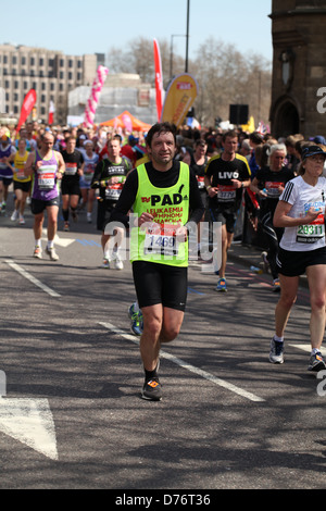 Ein Läufer konkurriert in 2013 Virgin London-Marathon für einen guten Zweck Stockfoto