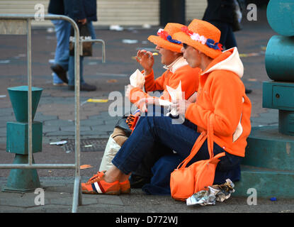 Amsterdam, Niederlande. 30. April 2013. Zwei Oranje-Fans genießen Sie eine Mahlzeit anlässlich der Einsetzung der neuen König des Landes, in Amsterdam. Foto: Britta Pedersen/dpa Stockfoto