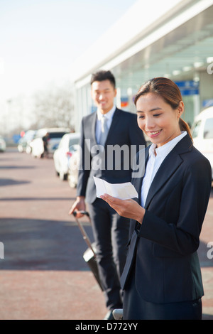 Reisenden, die am Ticket am Flughafen-Ankunftshalle Stockfoto
