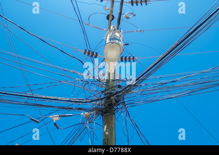 Eine leichte Holzstange unterstützt eine große Array von Kabel verheddert. Stockfoto