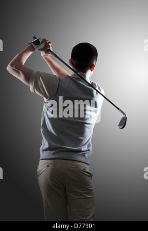 Junge golf Spieler schwingenden, hintere Ansicht Stockfoto