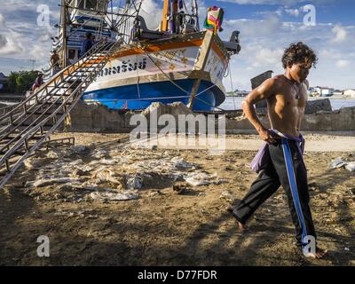 30. April 2013 - Mahachai, Samut Sakhon, Thailand - A birmanischen Crewman Weg von der Fischkutter geht, arbeitet er an, nachdem es zum Hafen in Mahachai zurückgekehrt. Burmesische Migranten Mannschaft viele Angelboote/Fischerboote und Mitarbeiter vieler die Fisch verarbeitende Betriebe in Samut Sakhon etwa 45 Meilen südlich von Bangkok.  Auch gab es Berichte, dass einige birmanische Arbeiter missbraucht und in Sklaverei wie Bedingungen statt. (Bild Kredit: Jack Kurtz/ZUMAPRESS.com ©) Stockfoto