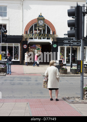 Eine Dame wartet beschäftigt Northallerton High Street zu überqueren, wo die wichtigsten Fußgängerüberweg befindet sich gegenüberliegenden Barkers Arcade Stockfoto