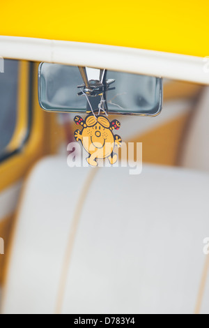 Gelbe benutzerdefinierte Zusammenfassung des VW Käfer. Little Miss Sunshine Zeichentrickfigur im Fenster Stockfoto