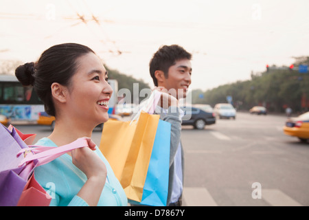 Junges Paar auf der Straße mit Einkaufstüten in Peking Stockfoto