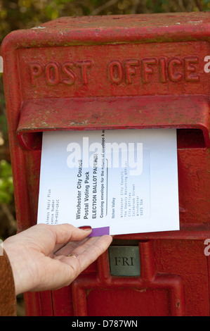 Briefwahl Umschlag, das in einem Royal Mail Sammlung Box Briefwahl Umschlag Entsendung rote Box Briefkasten Post Briefpost gesendet Stockfoto