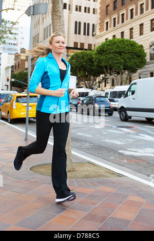 Frau läuft entlang der Urban Street Stockfoto