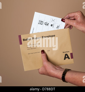 Wahlzettel X gegen die konservative Partei Box Papier wird in der Briefwahl Umschlag gesteckt Stockfoto