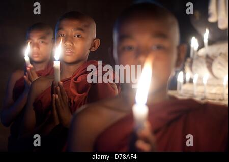 Eine Kerze in einem Tempel in Bagan, Myanmar, auf 01.04.2013 stehen drei junge buddhistische Mönche. Foto: Sebastian Kahnert Stockfoto