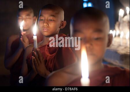 Eine Kerze in einem Tempel in Bagan, Myanmar, auf 01.04.2013 stehen drei junge buddhistische Mönche. Foto: Sebastian Kahnert Stockfoto